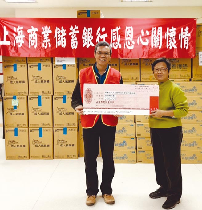 上海商銀資深副總經理彭國貴（左）代表銀行捐贈20萬元支票及物資一批，由華光秘書處副主任鄒佳蓉（右）代表接受。圖／上海商銀提供