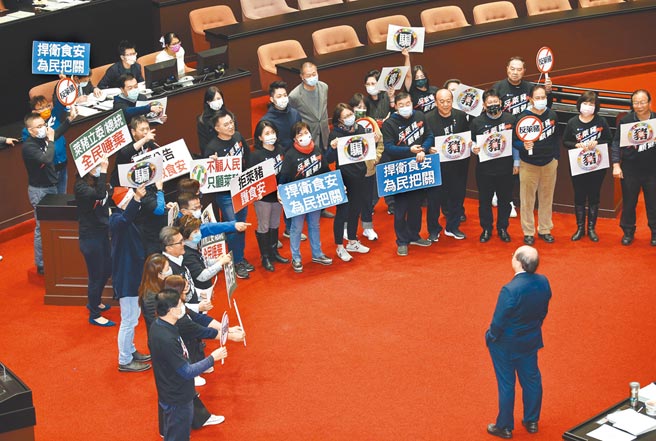 立法院24日表决莱猪9项行政命令与相关法案，当国民党举牌抗议时，民进党团总召柯建铭（右下）慢慢走到他们正前方冷眼对视。（姚志平摄）