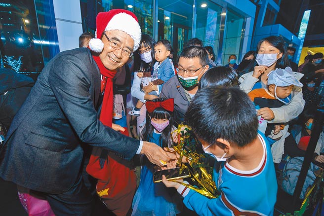 中信投信董事長陳國世（左一）發送糖果給小朋友，讓大朋友小朋友歡慶耶誕佳節。（中信銀行提供）