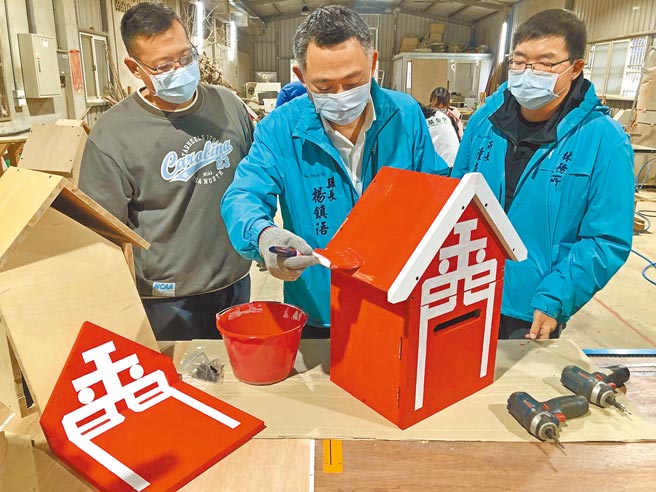 金門縣長楊鎮浯加入志工群，在公益電話亭刷下象徵愛心的大紅漆。（李金生攝）