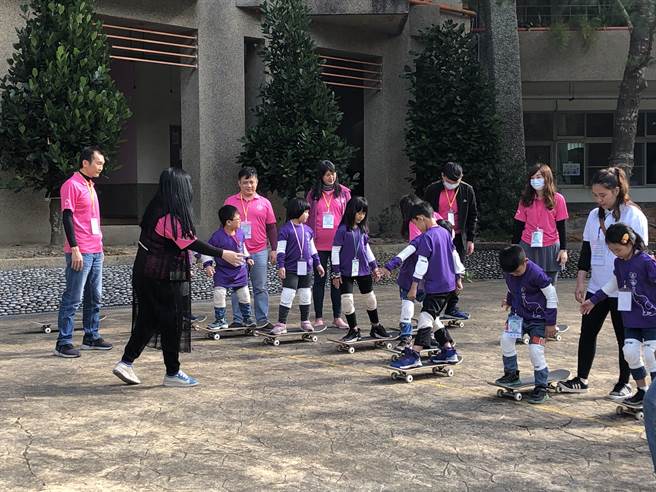 拜耳志工与小朋友一脚一脚溜着滑板玩的不亦乐乎。（魏怡嘉摄）