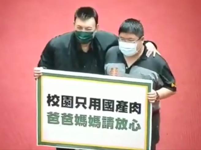 24日莱猪相关行政命令表决，民进党立委余天（左）拿看板拍照。（图／摘自罗友志YouTube）