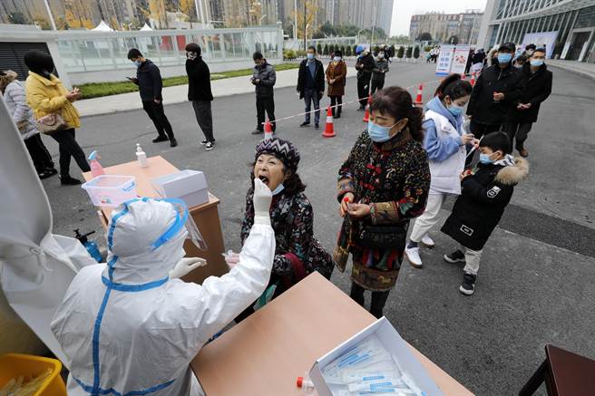 自12月23日，一名家住大陸北京市順義區、在海淀區工作的男性檢出新冠病毒陽性以來，截至12月26日，北京累計報告10名本土感染者。圖為醫務人員對居民進行核酸取樣。（新華社資料照）