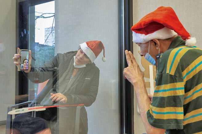 由於美國總統川普拒絕簽署新冠疫情紓困案，美國民眾仍等不到救急支票。圖為住在紐約布魯克林養老院的老人，在耶誕節與女兒會面。（路透）