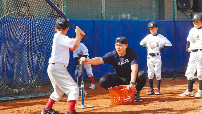 吉力吉捞．巩冠（中）明年投入选秀，参加棒球训练营指导小球员打击。（BE HEROES提供）