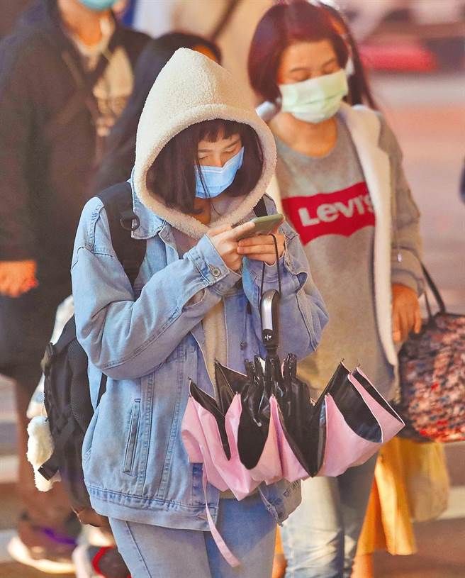 入冬首波寒流周三報到，民眾跨年、元旦務必注意。圖為夜間外出民眾穿上外套保暖。（劉宗龍攝）