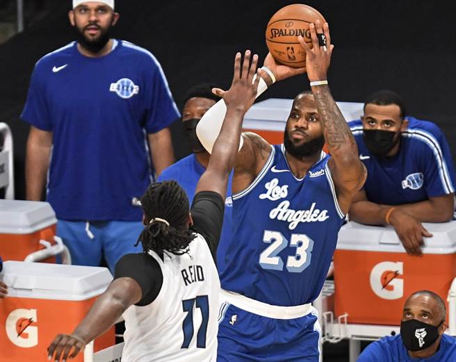 湖人前锋詹姆斯起身跳投，灰狼中锋瑞德扑上防守。(美联社)
