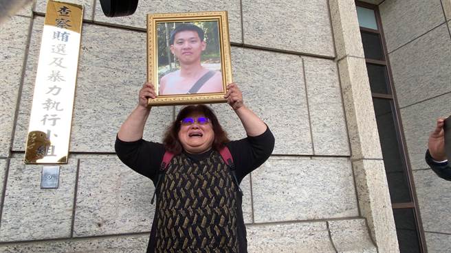 黄母讲到激动处，一度举起儿子的遗照。(蔡依珍摄)