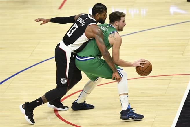 快艇保罗乔治(左)从后方防守独行侠东契奇。该场比赛快艇在主场被痛宰51分。（美联社资料照）