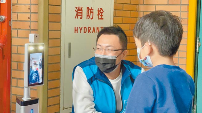 新北市议员王威元（左）28日媒合最新「AI智慧人脸辨识测温仪」，减少量测时间。（戴上容摄）