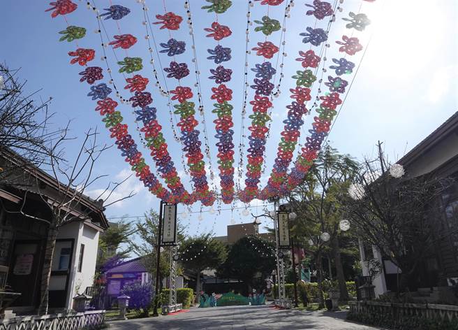 鹿港镇公所推出「彩色风车海」，共有红色客家花布，与绿、蓝、紫四色油桐花纹的风车1200个，在桂花巷艺术村走道上空转呀转，像是跳舞一般，营造澎湃视觉景观。（吴敏菁摄）