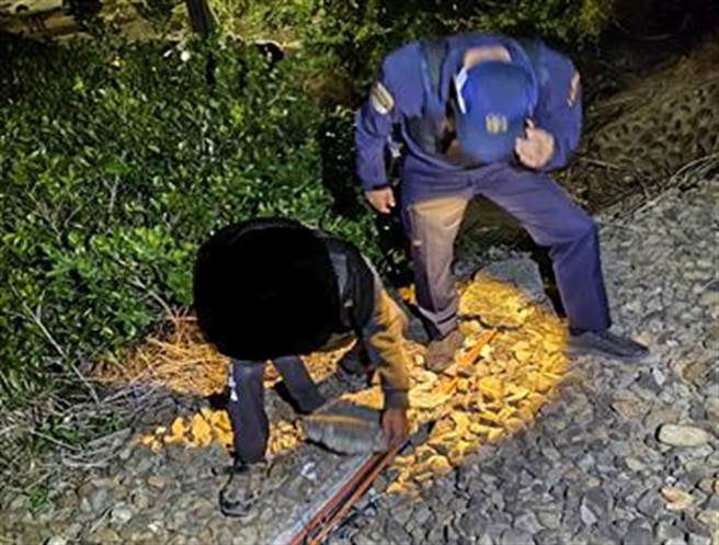 喜歡「搞軌」的羅男（左），被警方押到犯罪現場模擬放置「水泥槽蓋」讓火車輾壓。（新竹地檢署提供／羅浚濱新竹傳真）
