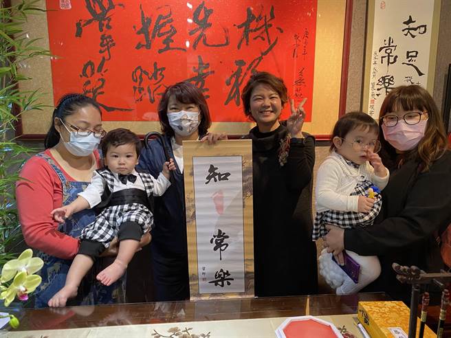 嘉义抓周文创馆开馆，市长黄敏惠（左三）为幼儿印脚掌，家长与小孩乐呵呵。（廖素慧摄）