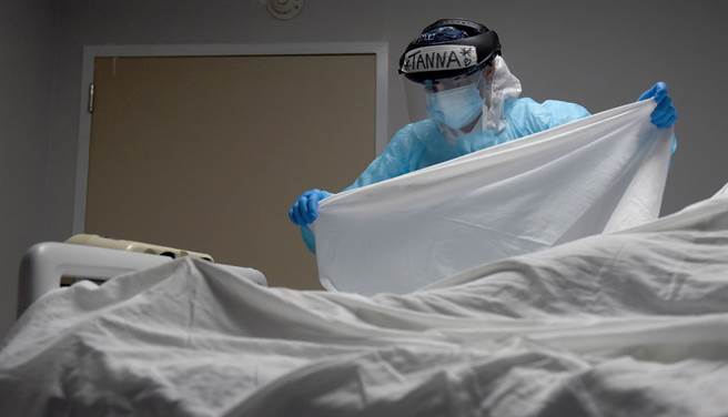 美国德州休士顿联合纪念医疗中心（United Memorial Medical Center）医护人员12月30日为新冠病患死者覆盖上白布。（路透）