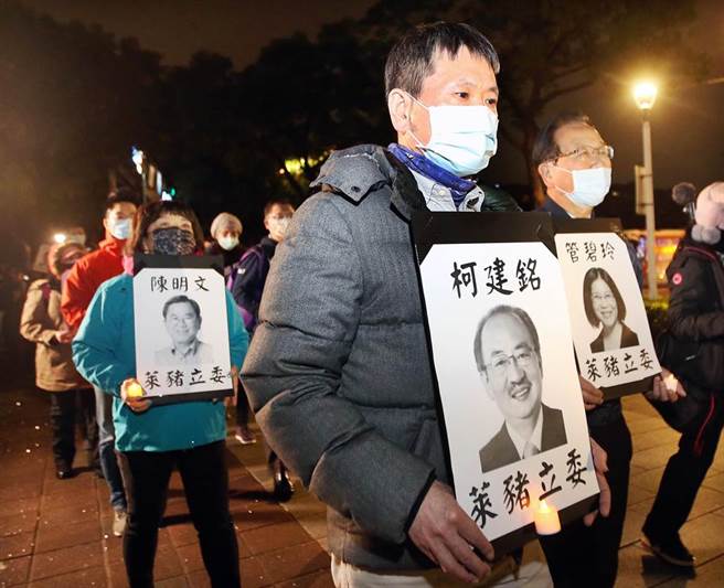 国民党团总召林为洲（中）率眾捧着赞成莱猪进口的绿营立委照片，加入「民主头七，静默游行」的抗议行列。（范扬光摄）