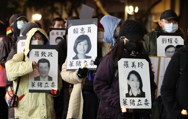 民眾纷纷捧着赞成莱猪进口的绿营立委照片，加入「民主头七，静默游行」的抗议行列。（范扬光摄）