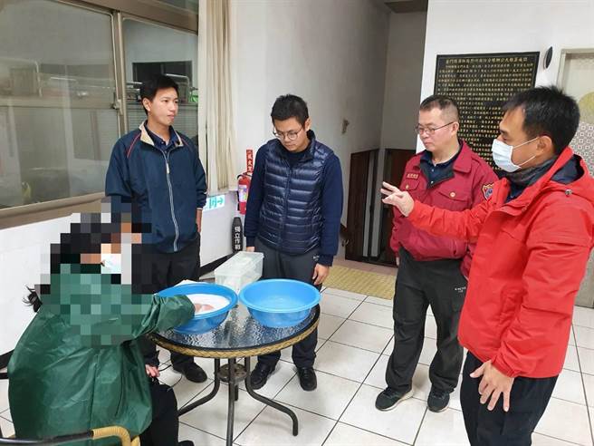 消防队员先让妇人将手指浸泡在温肥皂水约15分钟。（烈屿消防分队提供）