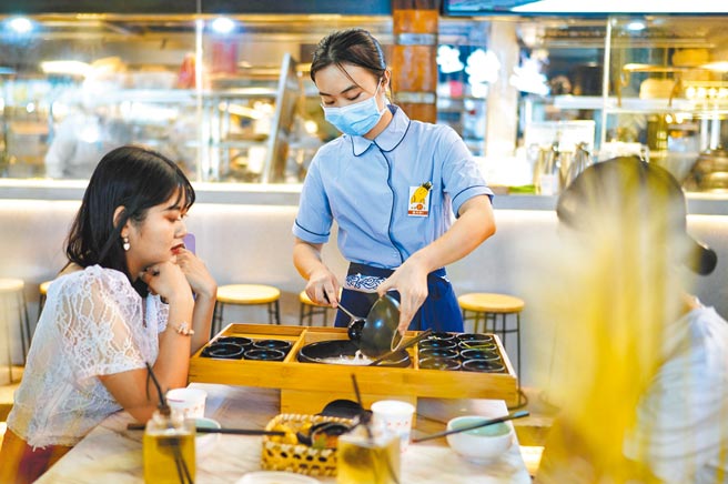 餐饮行业等可申请第一批接种新冠疫苗。图为一餐饮店服务员正在为顾客服务。（中新社）