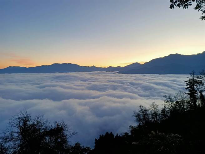 曙光尚未出现前，云海周围泛着青濛濛的亮光。（张毓翎摄）