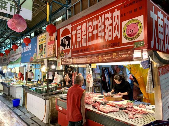 因应莱猪扩大进口，台南市「东菜市」的猪肉摊贩纷纷贴上国产猪标章，让民眾安心选购。（李宜杰摄）