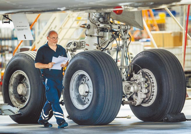 2020年7月30日，一名技師在德國法蘭克福機場的空中巴士輪胎旁走過。（美聯社）