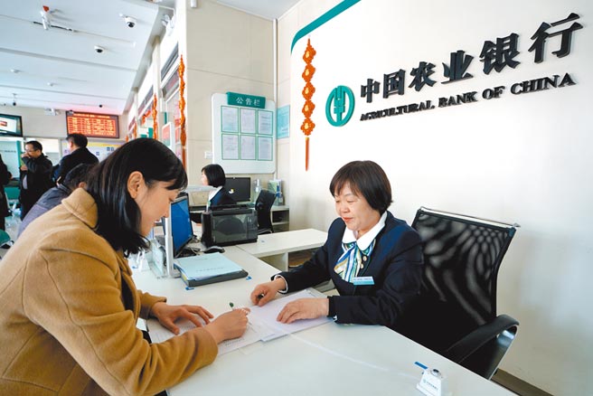 大陆国有大行持续在市场购买美元。图为中国农业银行行员为客户办理业务。 （新华社）