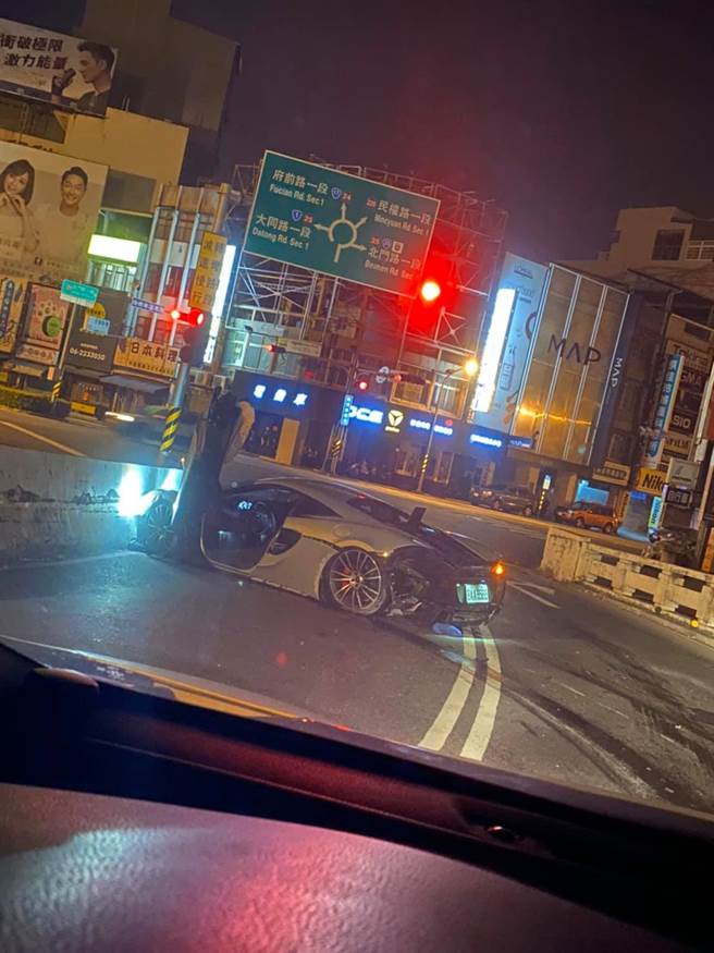 一輛白色「麥拉倫570S」在台南市東門圓環附近自撞分隔島。（圖／翻攝自臉書社團「台南爆料公社-台南最大社團」）