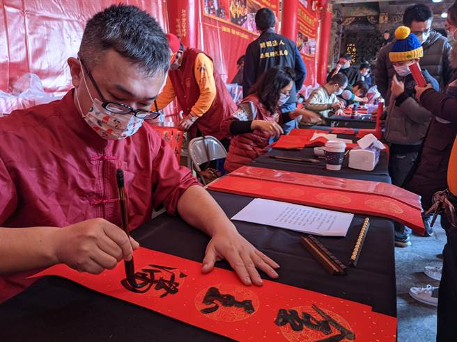 南鲲鯓代天府国历新年举办写春联、赠春联活动迈入第3年，因可拿到不同风格春联，颇受民眾欢迎。（庄曜聪摄）