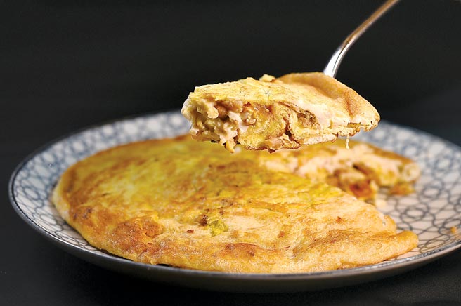 〈菜脯蛋〉的烹製工藝在業界享有盛名，外皮酥香、裡層柔軟潤滑，並可清楚咀嚼宜蘭菜脯的甘味。圖／姚舜