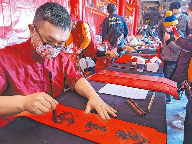 台南市北门区南鲲鯓代天府请书法家写春联送给民眾。（庄曜聪摄）