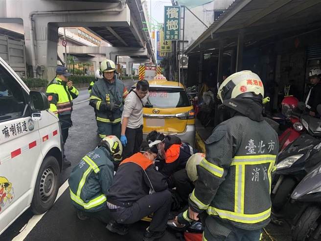23岁芶姓骑士失控打滑，撞击前方停靠黄线的计程车，整个人卡在车底。（图：民眾提供）