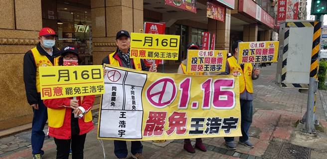 國民黨桃園市黨部、黃復興系統的黃國園黨部的志工，今冒著溼冷天氣站路口舉牌，宣傳16日罷王投票。（讀者提供）