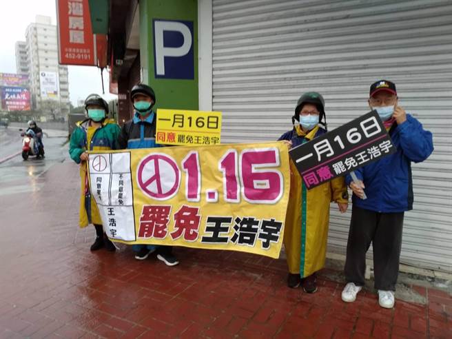 國民黨桃園市黨部、黃復興系統的黃國園黨部的志工，今冒著溼冷天氣站路口舉牌，宣傳16日罷王投票。（讀者提供）