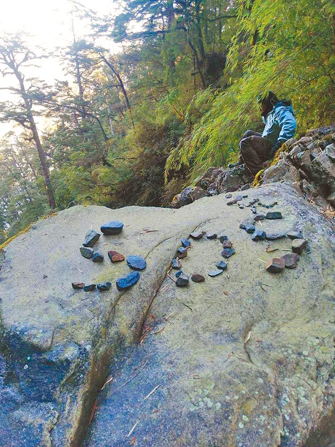 搜救人員在登仙溪發現陳姓山友以石塊堆成SOS求救信號。（南投縣消防局提供／廖志晃南投傳真）