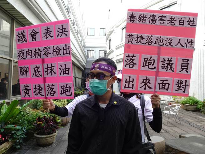 罷捷發言人徐尚賢得到消息，也帶人直衝議會，在黃捷開記者會的會議室門外守候，不時舉牌「毒豬傷害老百姓，黃捷落跑沒人性」要求辯論。（林宏聰攝）