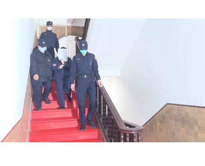 吴姓女子被押回囚车时，用纸掩脸。林伟信摄