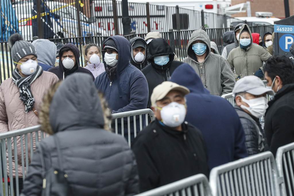 美國民眾在紐約皇后區埃姆赫斯特醫院（Elmhurst Hospital Center）前排隊等待檢測新冠肺炎的資料照。（美聯社）