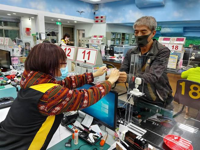 吕男从板桥户政事务所人员手中接下补发的身分证。（板桥户政事务所提供）