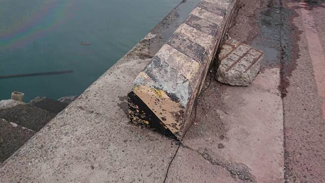 警方調查，該落海車輛的車頭前有撞擊痕跡，而港內邊緣石被車輛撞破。（張毓翎攝）