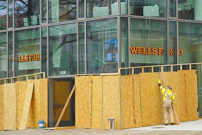 華盛頓市中心自由廣場購物中心為因應6日的百萬人大抗議，提前聘請工人將玻璃和入口用木板團團圍住。（美聯社）