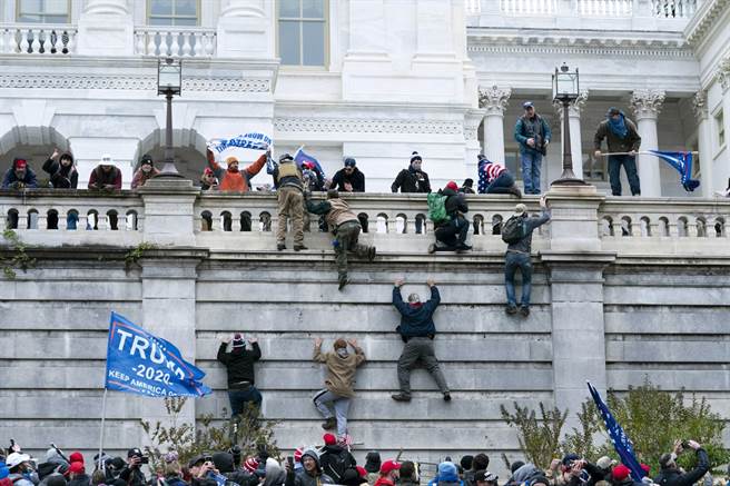 A large number of Trump fans gathered on the afternoon of the 6th to demonstrate in front of the American Club building, eventually running into the building, and some people even climbed on the wall.  (Photo / Associated press)
