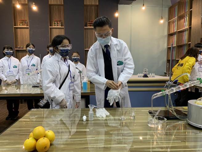 新竹市长林智坚（右）今天到建华国中特别穿上白袍化身实验家，在学生指导下，利用蒸馏的纯露、酒精调合乾洗手。（陈育贤摄）