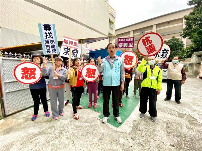 高市前镇区振兴里长锺明宪7日与社区长辈们拿手举牌表达不满，盼台电续借土地供关怀据点使用，并呼吁市府协助另觅合适空间。（林宏聪摄）