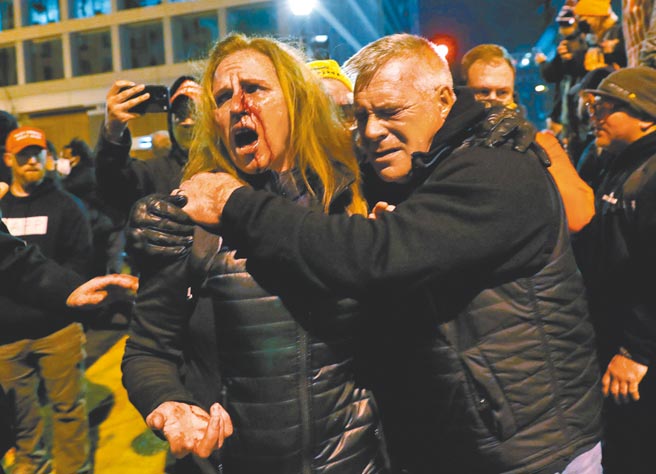 逾10万名川粉在华府誓言为川普而战。图为1名川粉在推挤中受伤，血流满面。（路透）