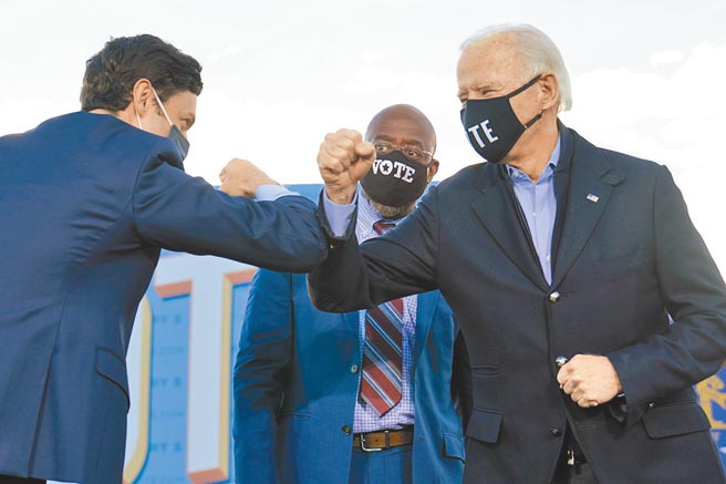 美喬治亞州參議員2輪決選，民主黨籍非裔牧師華諾克（中）確定勝選，奧索夫也自行宣布當選為民主黨掌控參眾兩院、完全執政再下一城。圖為總統當選人拜登日前與2參議員候選人擊肘。（美聯社）