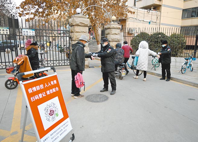 河北3日新增4例本地新冠確診病例，1月4日，石家莊一居民小區入口處，門衛正核驗進入小區人員的健康碼並測量體溫。（中新社）