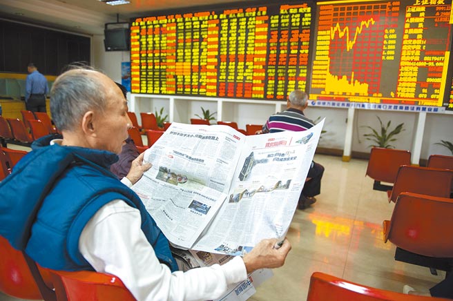 海口某证券交易大厅的股民在大盘前看报。（中新社资料照片）