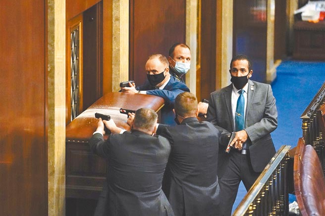 千钧一髮！极端川粉6日试图攻入眾议院议事厅，国会驻卫警设置障碍物，掏出手枪，场面紧张。（美联社）