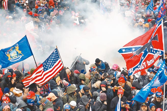 手持各类旗帜的极端川粉6日在国会山庄示威，与警方爆发严重衝突，国会驻警向准备强行闯入的川粉发射催泪瓦斯。（路透）
