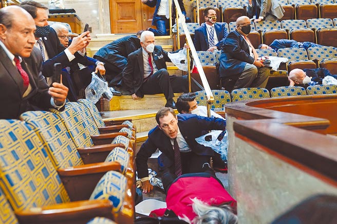 騷亂臨門，在眾議院，驚恐的眾人紛紛臥倒，找地方掩護。（美聯社）